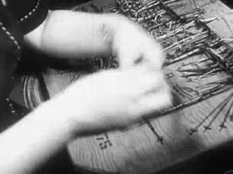 Close-up of hands stitching intricate patterns onto a fabric in an embroidery hoop.