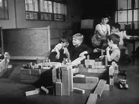Young children playing with building blocks in a bright indoor room