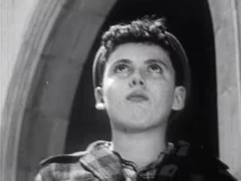 Close-up of a boy looking up thoughtfully towards an archway.