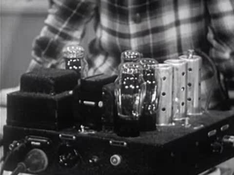 Composite of a microphone, electronic vacuum tube amplifier, and loudspeaker horn.