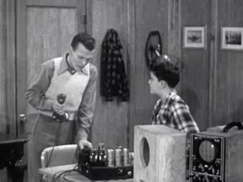 man and boy in workshop talking about sound wave equipment
