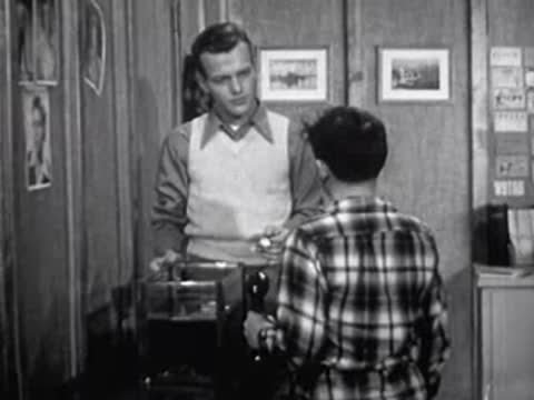 man looking at small object in his hands next to boy