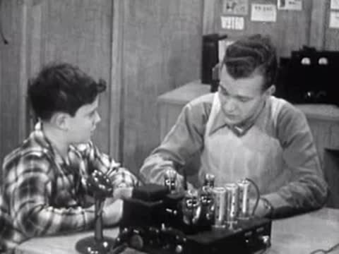 boy and man sitting at table discussing physics notes