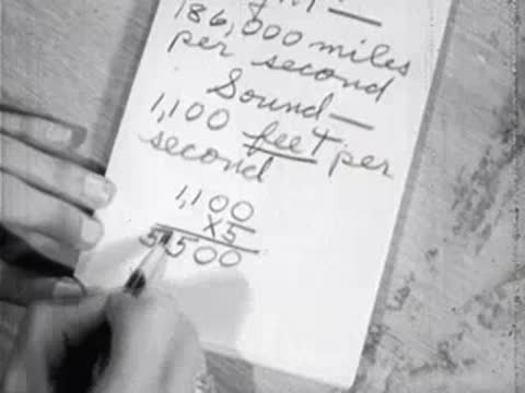 close-up of hand writing sound speed multiplication problem