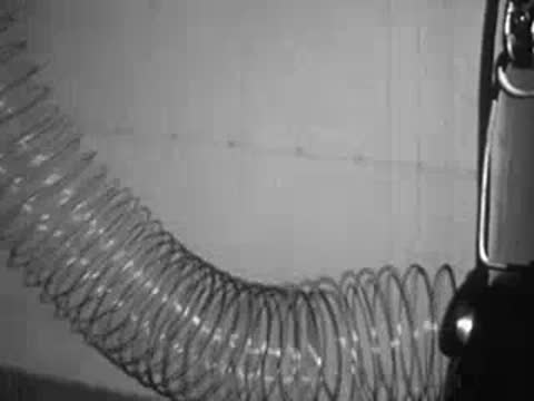 Close-up of metal spring coil compressing and extending in scientific demonstration