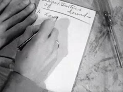 Hand writing notes on paper pad labeled characteristics of sound
