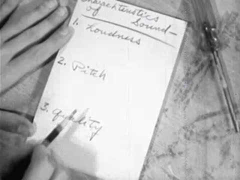 Hand writing notes on notepad in close-up shot during lesson