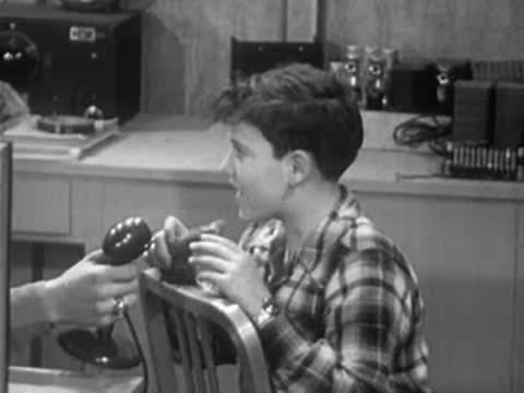 Boy speaking into microphone while instructor holds it in laboratory