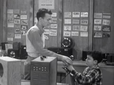 Instructor and boy holding microphones during audio demonstration in room