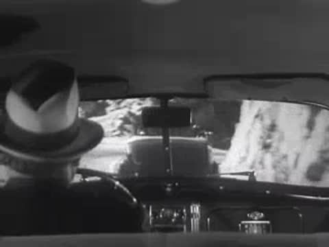 Driver's view navigating a winding mountain road.