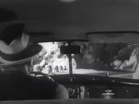Interior view of a car navigating a sharp curve on a mountain road.