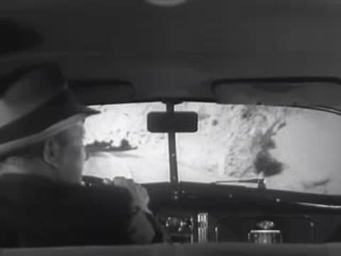 Driver's view looking at a winding mountain road ahead.