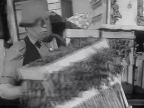 A man unloading crates of vegetables from the back of a truck.