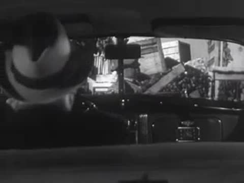 Driver's view looking at a man unloading crates from a truck.