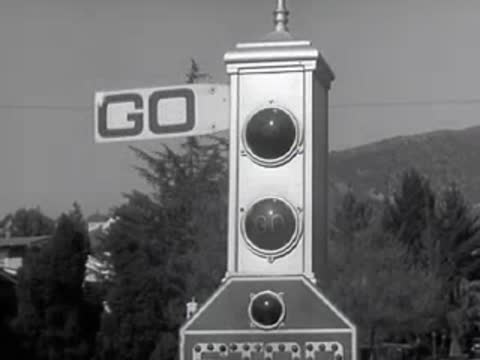 A traffic signal flips between STOP and GO positions.