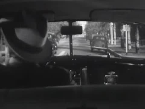 View from the back seat of a car driving down a city street.