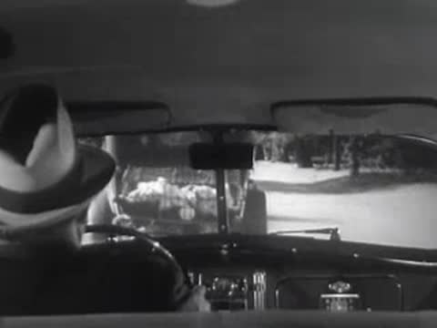 Interior view of a car looking out the back at another vehicle.