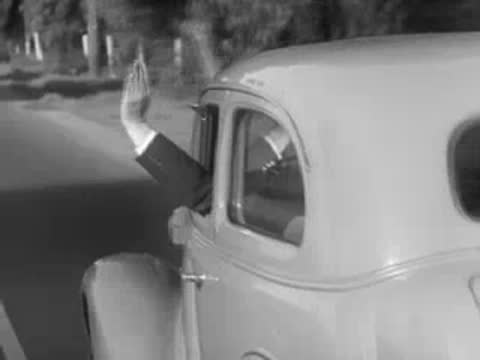 Arm extending out car window making driving hand signals.