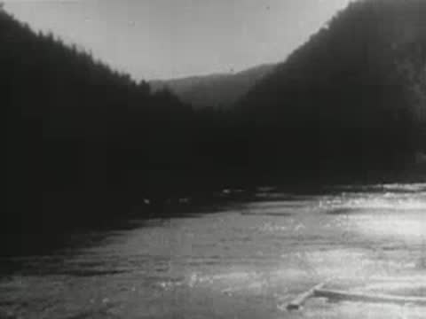 River flowing between tree-covered slopes and mountains
