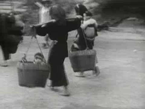 Person carrying children in baskets suspended from a shoulder pole
