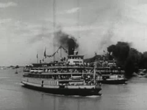 large paddle steamers traveling together on a wide river with smoke rising