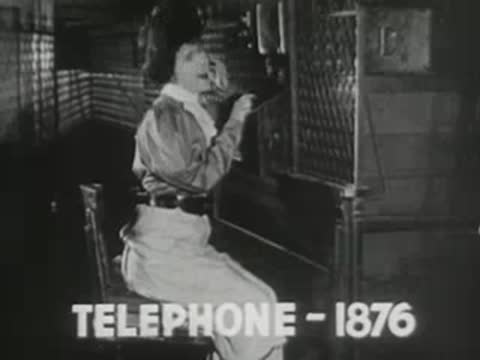 man in historical clothing sitting at a telephone switchboard operating equipment