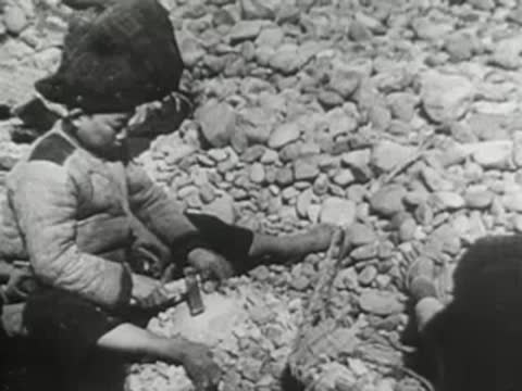 Close-up of a person hammering a stone fragment