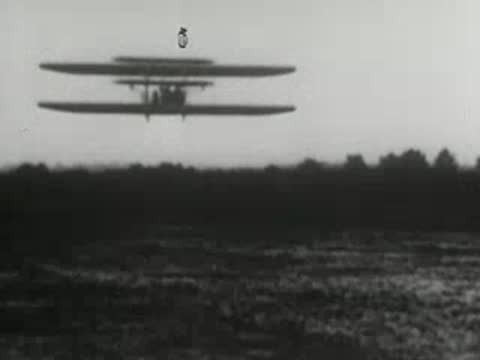Pioneering biplane in flight, early aviation history over flat terrain