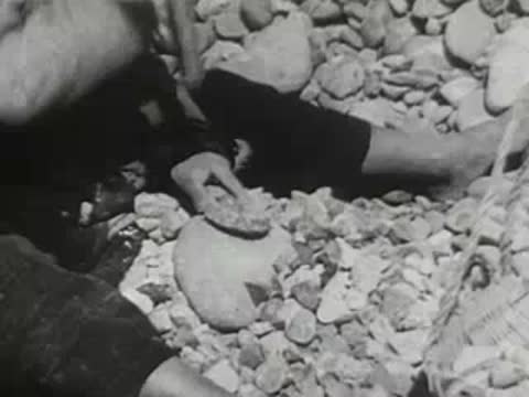 Person hammering small stones sitting on the ground