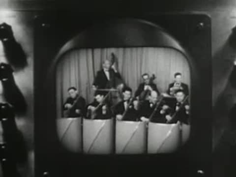Close-up of a television broadcast monitor displaying a live musical performance, early television technology