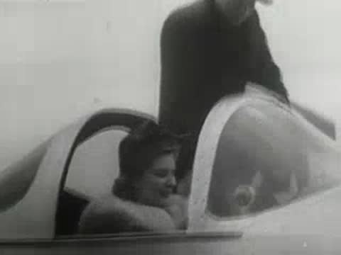 Woman smiling and sitting inside the cockpit of a modern light airplane, aviation history