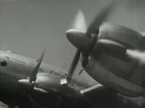 Propeller airplane engines spinning on the wing during flight, historical aviation footage.