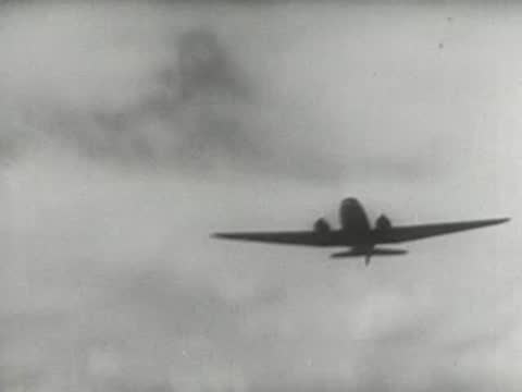 Airplane flying low over a wide open plain with hills