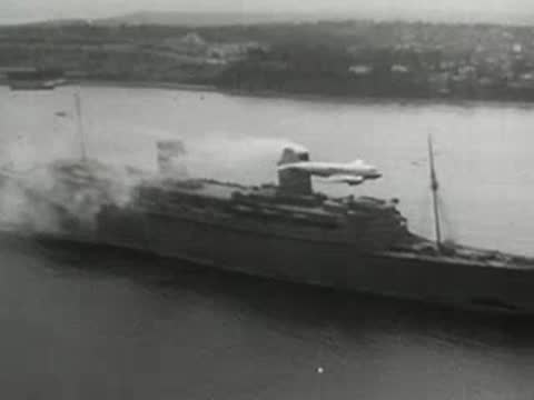 Seaplane taking off or landing near a steamship on a river, mid-20th century.