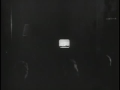 Small glowing television screen in a darkened room.