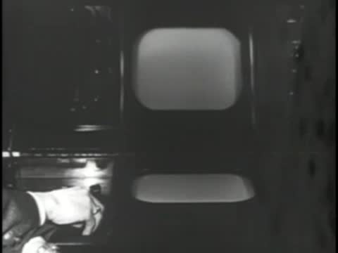 Close-up of television screen displaying images with hands pointing.