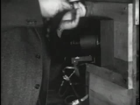 Technician installing or adjusting electronic components inside a cabinet.