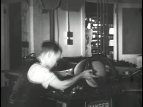 Technician assembles a cathode-ray tube inside a television chassis, 1930s style.