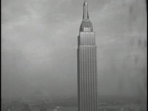 Exterior shot of the Empire State Building tower under an overcast sky.