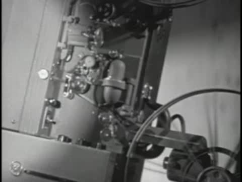 Scientists working on glass electronic tubes in a lab.