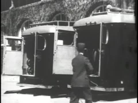 A crew member pulls a cable from the back of an RCA mobile van.