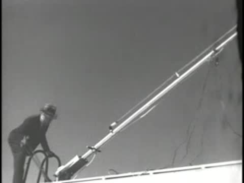 A telescopic antenna mast being raised or adjusted against a clear sky.
