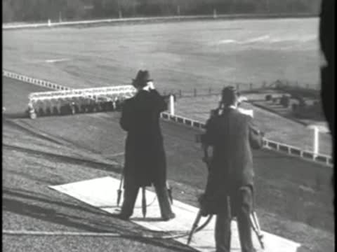 Men with binoculars and camera on racetrack, pre-war period style