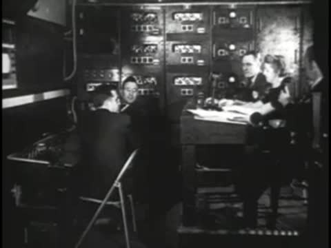 Broadcasting crew working at control desk with monitors and electronic equipment