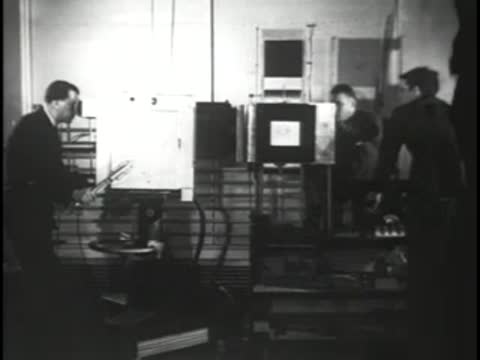 Studio production equipment with technicians monitoring screens and controls