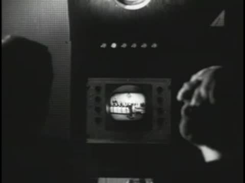 Sound engineer working in a dark control room with vintage monitors.
