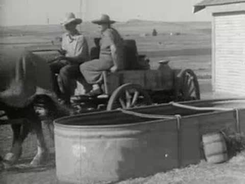 A horse-drawn cart stopping near a water tank on a farm, 1930s era