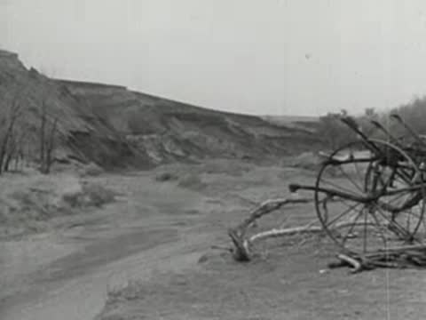 Dry landscape with ruined horse-drawn cart or wagon in foreground.
