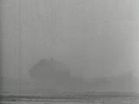 Medium shot of a small rural house barely visible through thick dust, 1930s