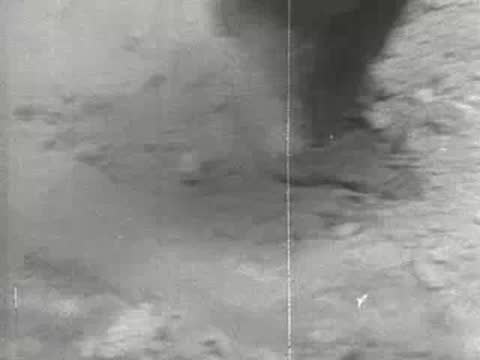 Close-up of boots walking heavily through dusty ground, 1930s